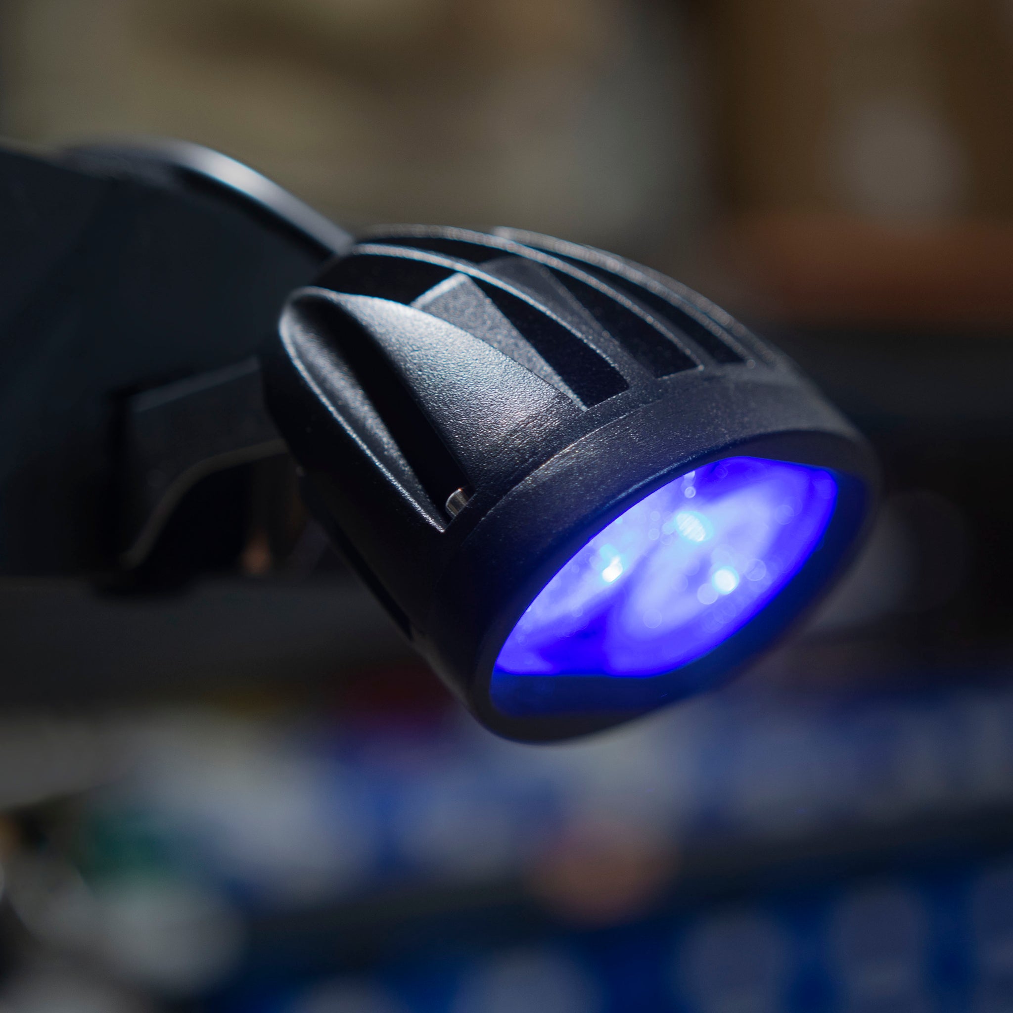 Black safety indicator light with blue light mounted on a fork lift.