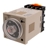 Front angled perspective of a tan industrial timer with black face and red needle. There is a black and orange adapter mounted to the rear of the timer on a white background.