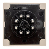 Rear of tan timer with black face and 8 metal pins on a white background.