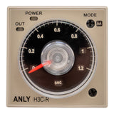 Front perspective of a tan industrial timer with black face and red needle on a white background.