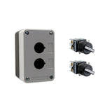 Black and grey push button box with two holes, held together by four phillips head screws next to two black and white 2-position selector switches on a white background.
