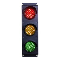 Triple red, amber and green traffic light on a white background.
