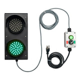 Front perspective of a black four inch 2-light traffic light with green illuminated, mirrored by a green illuminated pilot light on a connected 2-position switch control box. A grey cable connects the two units with a black 3-prong power cord coming from the bottom of the control box.