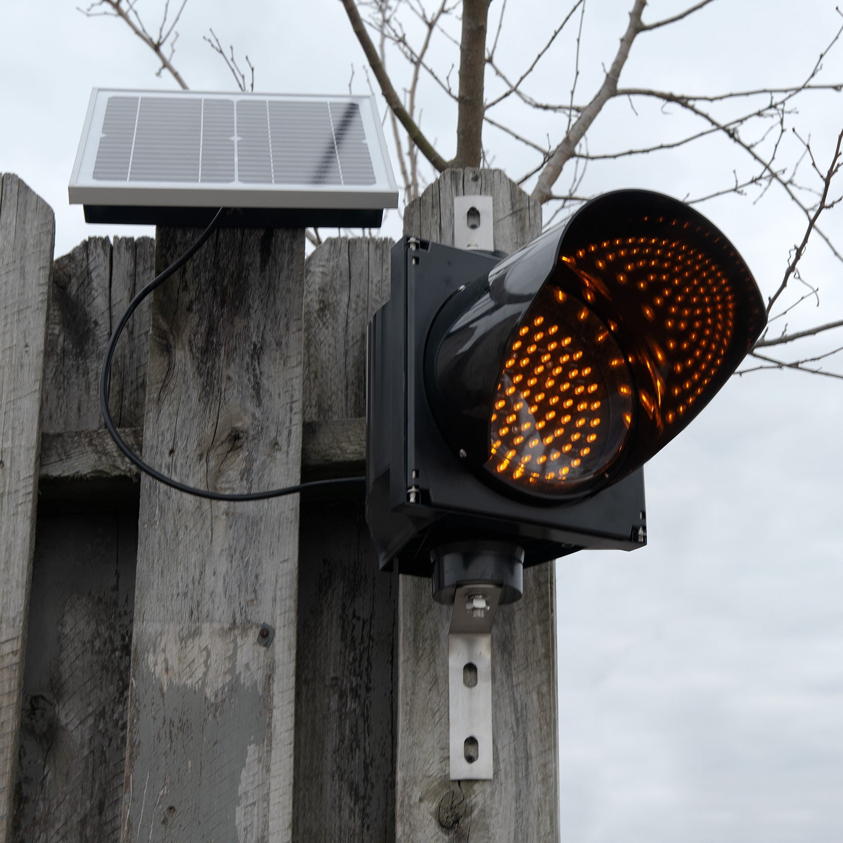 Amber solar powered 8 inch traffic light mounted outdoors.