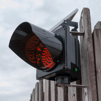 Red solar powered 8 inch traffic light mounted outdoors.