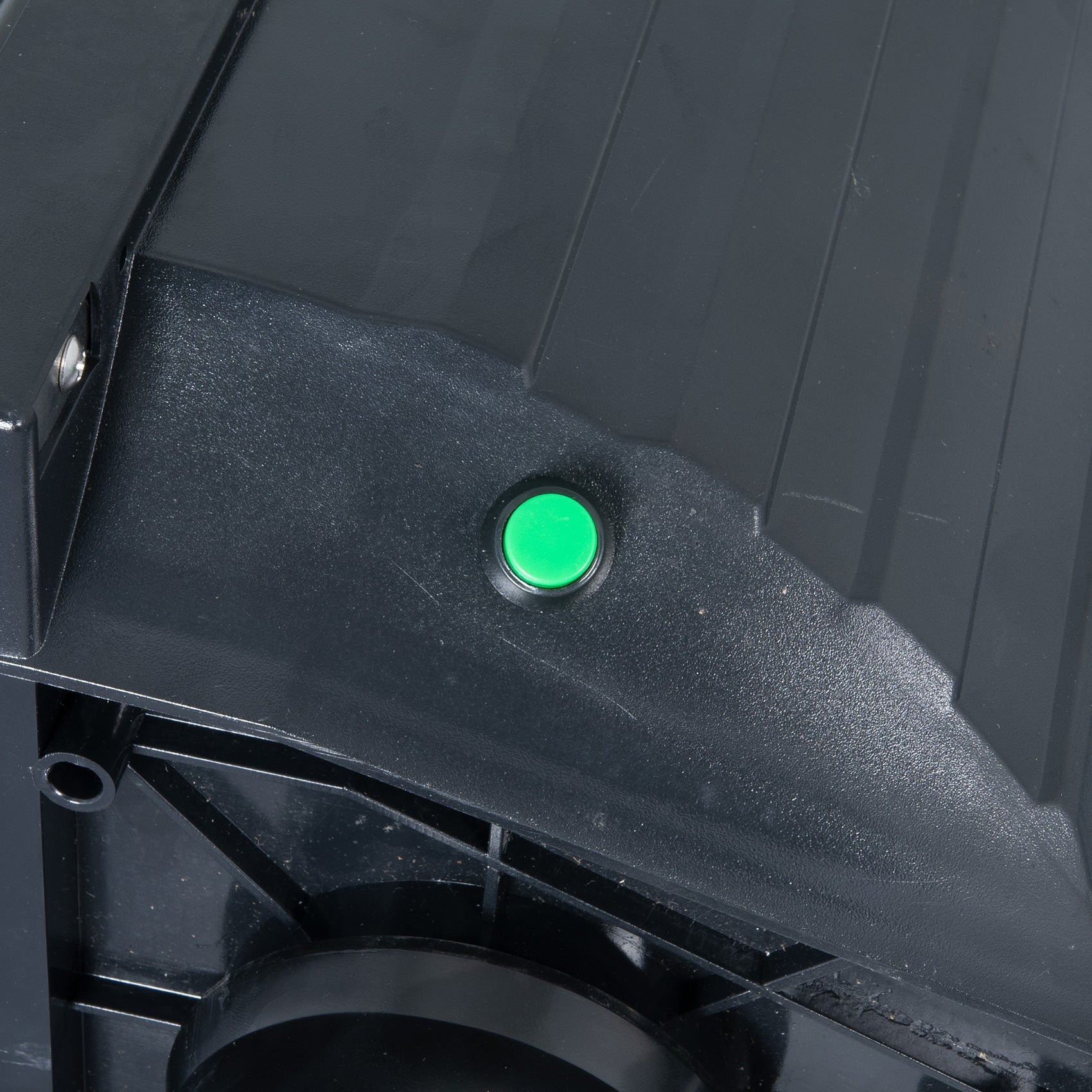 Close up of green power button on black polycarbonate traffic light.
