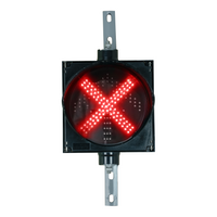 An 8 inch diameter LED traffic light signal featuring a red X in a black polycarbonate housing on a white background.