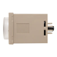 Side profile of tan timer with clear dial and four visible pins on rear.